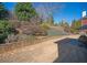 Expansive backyard with a landscaped stone retaining wall on a clear sunny day at 942 Heathchase Dr, Suwanee, GA 30024