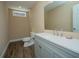 Bathroom with white vanity, modern fixtures, and wood-look flooring at 942 Heathchase Dr, Suwanee, GA 30024