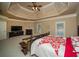 The spacious main bedroom features carpeted floors and a decorative trey ceiling at 942 Heathchase Dr, Suwanee, GA 30024