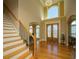 Grand foyer with a staircase, high ceilings, hardwood floors, and a decorative chandelier at 942 Heathchase Dr, Suwanee, GA 30024