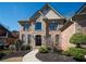 Elegant brick home featuring a stone facade, arched windows, and professional landscaping at 942 Heathchase Dr, Suwanee, GA 30024