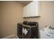 Laundry room features a front load washer and dryer set with white cabinetry above at 942 Heathchase Dr, Suwanee, GA 30024