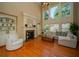 Bright and airy living room featuring a fireplace, built-in shelving, and large windows overlooking backyard at 942 Heathchase Dr, Suwanee, GA 30024