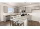 Modern kitchen featuring gray cabinets, a granite island with seating, stainless steel appliances, and hardwood flooring at 3511 Summerlin Pkwy, Lithia Springs, GA 30122