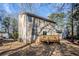 Exterior house view with a deck and a spacious backyard partially fenced with mature trees and shrubs at 5438 Zachary Dr, Stone Mountain, GA 30083