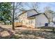Back exterior of this home featuring a wood deck, fenced in yard and mature trees at 5438 Zachary Dr, Stone Mountain, GA 30083