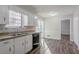 A kitchen featuring white cabinetry and a double stainless steel sink and updated flooring at 5438 Zachary Dr, Stone Mountain, GA 30083
