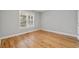 Bright bedroom features hardwood floors, neutral paint, and a window with blinds at 1551 Avon Ave, Atlanta, GA 30311