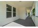 Covered porch with painted wood siding, large windows and a gray concrete floor at 1551 Avon Ave, Atlanta, GA 30311