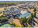 Aerial view of a large pool with a covered area and adjacent tennis court in a residential community at 3760 Lake Point Blvd, Suwanee, GA 30024