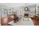 Open-concept living room with a fireplace, hardwood floors, a ceiling fan, and a breakfast nook in the background at 3760 Lake Point Blvd, Suwanee, GA 30024