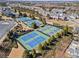 Aerial view of multiple tennis courts with blue and red surfaces, surrounded by lush greenery at 3760 Lake Point Blvd, Suwanee, GA 30024