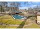 Aerial view of an in-ground pool covered for the winter in the backyard of a brick house at 3806 Lindley Cir, Powder Springs, GA 30127