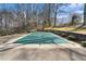 An in-ground pool featuring a safety cover is surrounded by mature trees and landscaping at 3806 Lindley Cir, Powder Springs, GA 30127