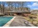 An in-ground pool with a safety cover is near the brick house on a spacious lot at 3806 Lindley Cir, Powder Springs, GA 30127