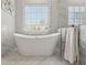 Elegant bathroom with a freestanding tub, marble accents, and a large window at 4434 Oglethorpe Nw Loop, Acworth, GA 30101