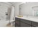 Bathroom featuring marble tile, dark gray vanity, and shower with tub at 4434 Oglethorpe Nw Loop, Acworth, GA 30101