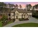 Elegant stone exterior with a grand entrance and well-manicured landscaping at sunset at 4434 Oglethorpe Nw Loop, Acworth, GA 30101