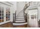 Elegant foyer featuring a curved staircase with dark wood accents and bright white walls at 4434 Oglethorpe Nw Loop, Acworth, GA 30101