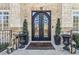 Close-up of the ornate arched front doors with decorative ironwork and manicured potted plants at 4434 Oglethorpe Nw Loop, Acworth, GA 30101