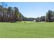 Lush green golf course with scattered trees and sand traps under a blue sky at 4434 Oglethorpe Nw Loop, Acworth, GA 30101