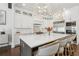 Gourmet kitchen with white cabinets, stainless appliances, a large island with seating, and stylish lighting at 4434 Oglethorpe Nw Loop, Acworth, GA 30101