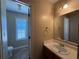 Bathroom featuring a white vanity, large mirror with vanity lighting and an adjacent commode room at 904 Crossing Rock Dr, Lawrenceville, GA 30043