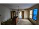 Dining room with stained walls, vintage chandelier and worn carpet at 1687 Neely Ave, Atlanta, GA 30344