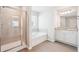 Light filled bathroom with a glass shower, soaking tub, a modern single vanity and neutral color palette at 2019 Wyndham Pl, Conyers, GA 30013