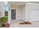 A well-lit front entrance with white columns, siding, and a two car garage at 2019 Wyndham Pl, Conyers, GA 30013