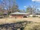 The backyard showcases a brick home with a well-maintained lawn and mature trees at 3606 Trickum Ne Rd, Marietta, GA 30066