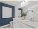 Bright bathroom featuring a double vanity, white cabinets, and blue accent wall for a modern touch at 6094 Marigold Way, Atlanta, GA 30349