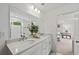 Bathroom featuring a double vanity with white cabinets and quartz countertop, adjacent to the bedroom at 6094 Marigold Way, Atlanta, GA 30349