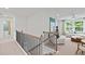 Hallway with wood and iron staircase leading to a bright, naturally lit living space at 6094 Marigold Way, Atlanta, GA 30349