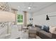 Bright living room featuring modern furnishings, stylish decor and natural light from a window overlooking the yard at 6094 Marigold Way, Atlanta, GA 30349