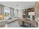 Bright home office featuring a modern light fixture, built-in shelving, and a comfortable seating area at 6094 Marigold Way, Atlanta, GA 30349