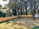 Large, fenced backyard with mature trees and a storage shed at 2257 Collins Dr, East Point, GA 30344