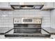 Close-up of a stainless steel stove with white tile backsplash and range hood at 3242 Kingswood Gln, Decatur, GA 30034