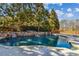 A luxurious backyard pool features a stone waterfall and lush landscaping, creating a private oasis at 3277 Aberrone Pl, Buford, GA 30519