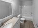 Well-lit bathroom with tiled floor, vanity, toilet and a shower-tub combo at 4200 Flakes Mill Manor Ln, Ellenwood, GA 30294