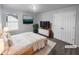 This staged main bedroom features a queen-size bed and a spacious double door closet at 4200 Flakes Mill Manor Ln, Ellenwood, GA 30294
