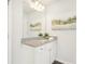 Well-lit bathroom vanity with granite countertops, a decorative mirror and sconce lighting at 2021 Wyndham Pl, Conyers, GA 30013