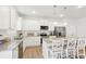 Stylish kitchen boasting white cabinetry, stainless steel appliances, granite countertops, a center island, and light wood flooring at 2021 Wyndham Pl, Conyers, GA 30013