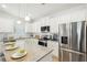 Bright kitchen with stainless steel appliances, granite countertops, white cabinets and a large refrigerator with water dispenser at 2021 Wyndham Pl, Conyers, GA 30013