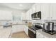 Well-equipped kitchen with stainless steel appliances, granite countertops, white cabinets and a large window at 2021 Wyndham Pl, Conyers, GA 30013
