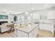 Open-concept kitchen with granite counters, stainless steel appliances, white cabinets, a large island and adjacent living space at 2021 Wyndham Pl, Conyers, GA 30013