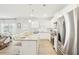 Open-concept kitchen featuring a large island with seating, stainless steel appliances, white cabinets and light-filled living area at 2021 Wyndham Pl, Conyers, GA 30013
