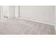 Large open living room with light gray walls, light gray carpet, and a doorway to the kitchen at 2021 Wyndham Pl, Conyers, GA 30013