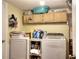 Laundry room with stacked washer and dryer and overhead cabinets for convenient storage at 2573 Mistletoe Ln, Snellville, GA 30039