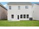 Backyard view of home, featuring a well-maintained lawn, concrete patio, and double hung windows at 2023 Wyndham Pl, Conyers, GA 30013